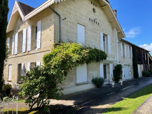 een groot bakstenen gebouw met struiken ervoor bij Domaine de Monein in Saint-André-de-Cubzac