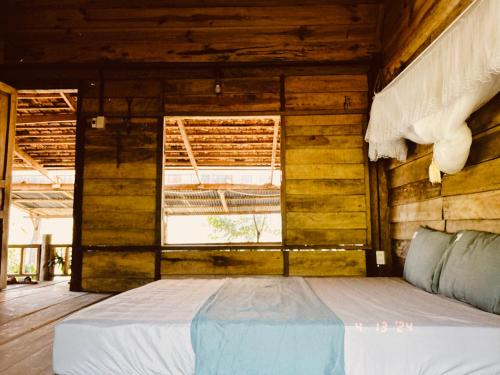 Posto letto in camera in legno con finestra. di An Homestay a Di Linh