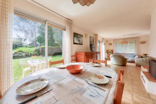 un salon avec une table et une grande fenêtre dans l'établissement St Pierre de Quiberon - Maison 6 Personnes, à Saint-Pierre-Quiberon