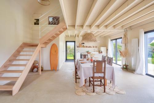 une salle à manger avec une table et un escalier dans l'établissement À 1km de la plage de Pors carn, maison pour 6, à Penmarcʼh