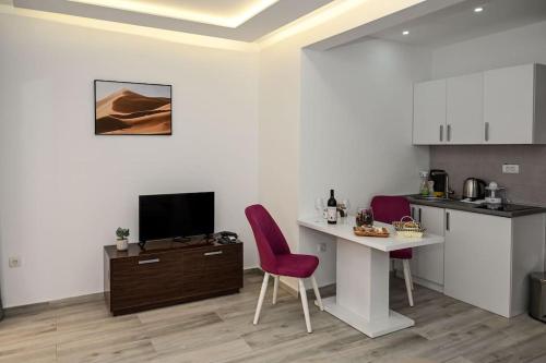 a living room with a desk and a table and chairs at Vujovic Studio Apartment in Tivat