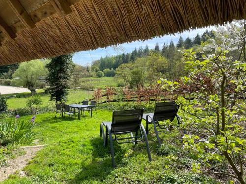 a group of chairs sitting in the grass at Le Manoir du Perroy in Saint-Wandrille-Rançon