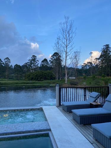 une terrasse avec une piscine et des chaises à côté d'un lac dans l'établissement Monarch Campestre, à Rionegro