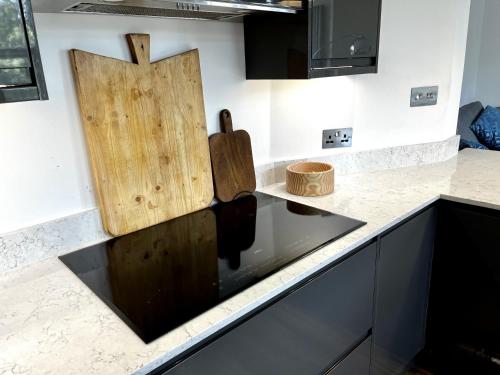 uma cozinha com um lavatório com tábuas de corte de madeira no balcão em Luxury apartment with 2-Beds em Beckenham