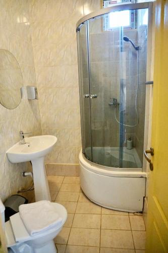 a bathroom with a shower and a toilet and a sink at Cazare Alfredo in Craiova