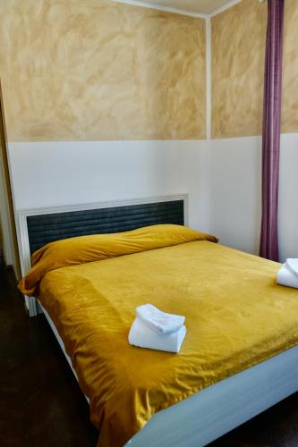 a large yellow bed with two white towels on it at Cazare Alfredo in Craiova
