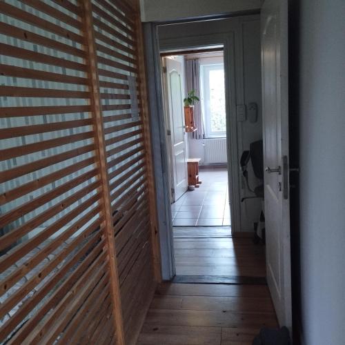 a hallway with a wooden slat door in a house at Au fil des champs in Berzée