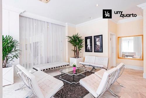 uma sala de estar com mobiliário branco e uma mesa em MANHATTAN FLOOR em Curitiba