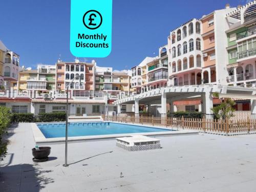 a large apartment with a swimming pool in front of some buildings at Blue Sea Unique Apartment in Torrevieja - Short walk to the beach in Torrevieja