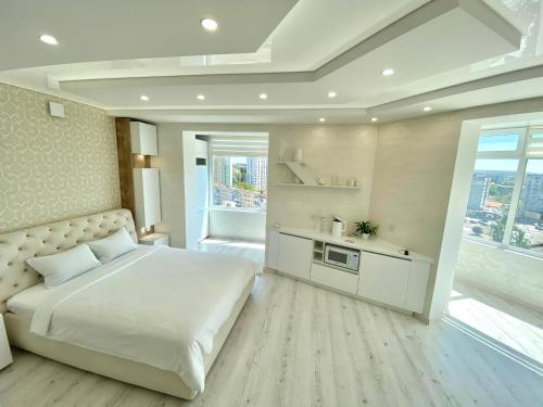- une chambre avec un grand lit blanc et une fenêtre dans l'établissement Кращі панорамні квартири Sky House у центрі Вінниці Безключовий доступ!, à Vinnytsia