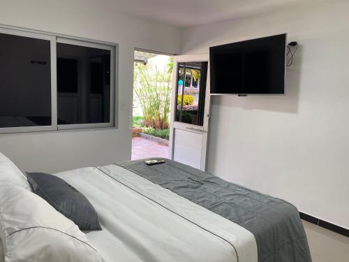 a bedroom with a bed and a flat screen tv at Malokas Resort - Socorro - San Gil in Socorro