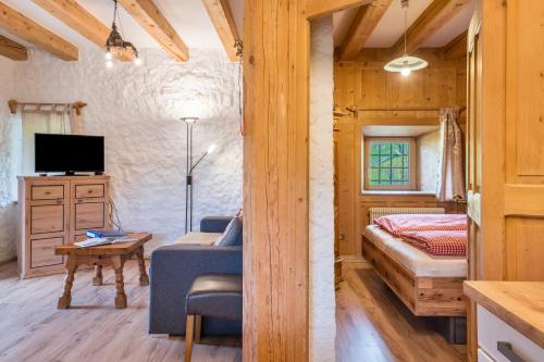 a bedroom with a bed and a tv in a room at Stofnerhof Turmgemach in Sarntal