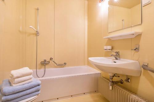 a white bathroom with a sink and a bath tub at Stofnerhof Turmgemach in Sarntal