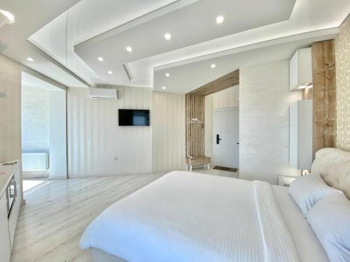 a large white bedroom with a large white bed at Кращі панорамні квартири Sky House у центрі Вінниці Безключовий доступ! in Vinnytsya