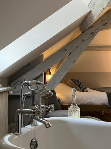 a bathroom with a bath tub and a bed at Chambres d'hôtes du château in Boulogne-sur-Mer