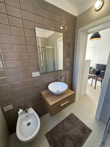 ein Badezimmer mit Waschbecken, Toilette und Spiegel in der Unterkunft Appartamento a pochi passi dal mare in Bellaria-Igea Marina