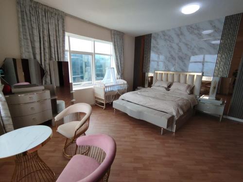 um quarto com uma cama, uma mesa e cadeiras em شقة فخمة وواسعة غرفتين luxury and big 2BR em Ajman
