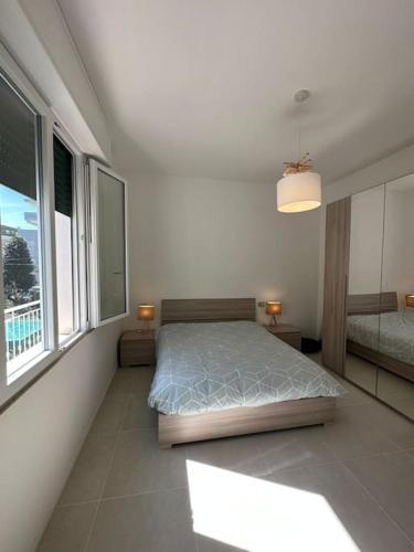 ein Schlafzimmer mit einem Bett und einem großen Fenster in der Unterkunft Appartamento a pochi passi dal mare in Bellaria-Igea Marina