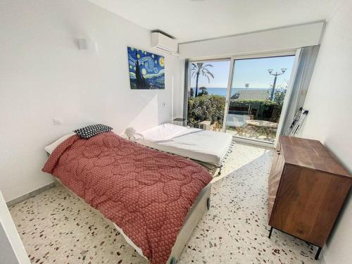 une chambre avec un lit et une grande fenêtre dans l'établissement menton roquebrune Cap Martin Monaco face mer, à Roquebrune-Cap-Martin