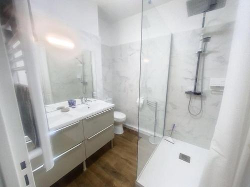 une salle de bain blanche avec un lavabo et une douche dans l'établissement menton roquebrune Cap Martin Monaco face mer, à Roquebrune-Cap-Martin