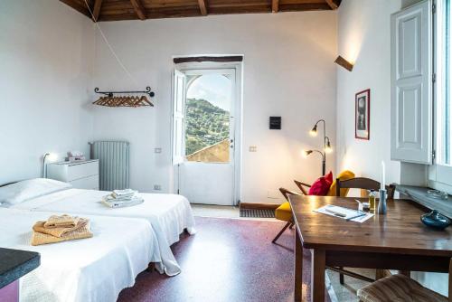 a bedroom with a bed and a table and a window at Sparviero - ACrapa Mangia in Santa Maria di Castellabate