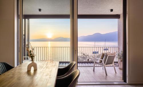 a dining room with a table and a view of the ocean at SalvatoreHomes - Luxurious Dreamview Waterfront Apartment in Torri del Benaco with Pool in Torri del Benaco