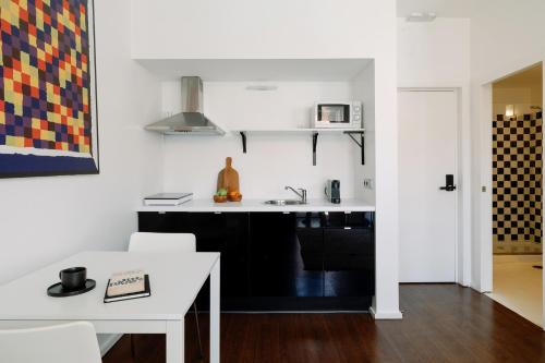 cocina con encimera blanca y mesa blanca en Fine Arts Studios by Olala Homes, en Oporto