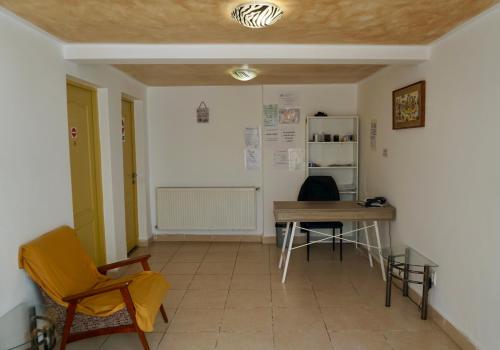 a room with a table and chairs and a desk at Cazare Alfredo in Craiova