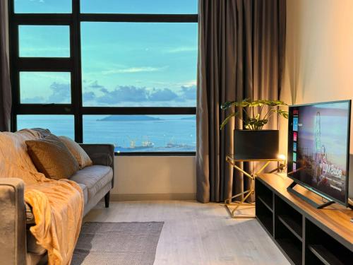 a living room with a couch and a large window at CUSH @ Jesselton Quay Seaview in Kota Kinabalu