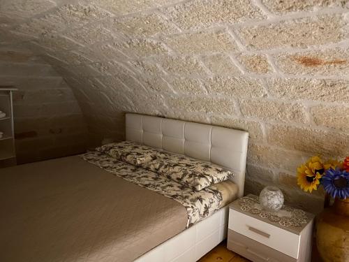 ポリニャーノ・ア・マーレにあるCasa Dolce Casa Locazione Turisticaのレンガの壁のドミトリールームのベッド1台分です。