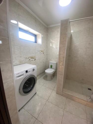 uma casa de banho com uma máquina de lavar roupa e um WC em 31 em Naryn
