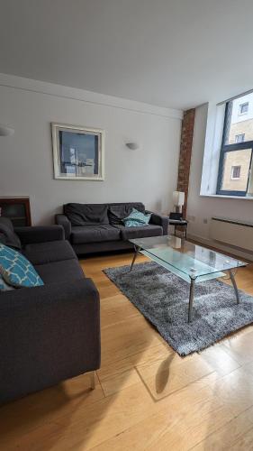 a living room with a couch and a glass table at Impeccable 2-Bed Apartment in London in London