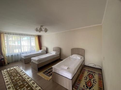 uma sala de estar com duas camas e uma janela em 31 em Naryn