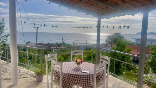 una persona de pie en una mesa en un balcón con el océano en Tony Home en Borsh