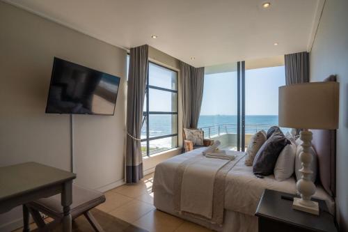 ウムドロティにあるLuxury Beachfront Apartment - 30 Degrees Umdlotiの海の見えるベッドのある寝室