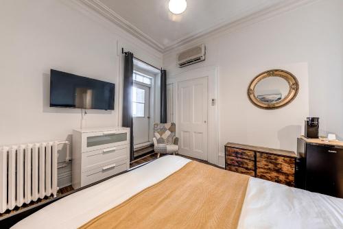 a bedroom with a bed and a flat screen tv at Hôtel Automatisé Manoir des Remparts in Quebec City