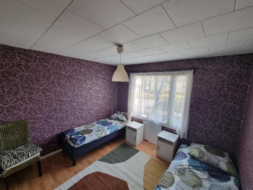 1 dormitorio con paredes moradas, 1 cama y 1 silla en Villa Anna en Rauma