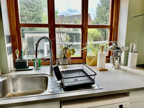 fregadero de cocina con tendedero junto a una ventana en 4 bed family home + Garden Twickenham., en Twickenham