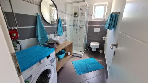 une salle de bain avec une machine à laver et un lavabo dans l'établissement Apartman Dado, à Cres