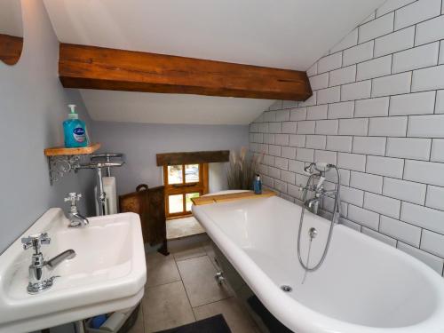Gallivantin Cottage في ليبرن: حمام مع مغسلتين وحوض استحمام
