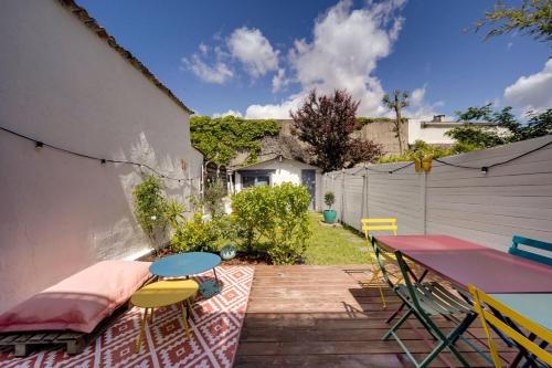 d'une terrasse avec une table, des chaises, une table et une clôture. dans l'établissement Très bel appartement avec Terrasse et Jardin, à Bordeaux