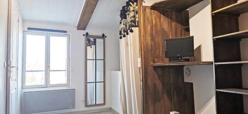 a room with a window and a tv on a shelf at Maison Village Cosy - Wifi - 2 VTT - 5 km plage in Villelongue-de-la-Salanque