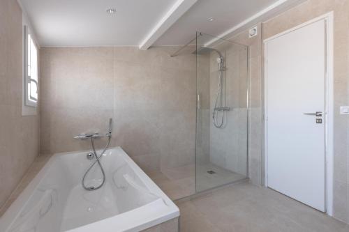 une salle de bain avec douche et baignoire blanche dans l'établissement A3B047 TRIPLEX MODERNE TERRASSE vue MER, à Cannes