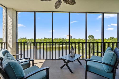 a screened in porch with blue chairs and a table at Santo Amaro Unit 301B at Lost Key Golf & Beach Club in Pensacola