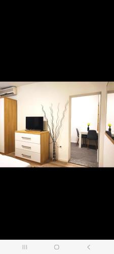a bedroom with a dresser with a television and a table at Apartments Gavran 3 in Baška Voda