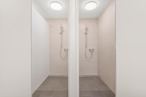 a bathroom with white walls and a walk in shower at Lénger Schoul in Bascharage