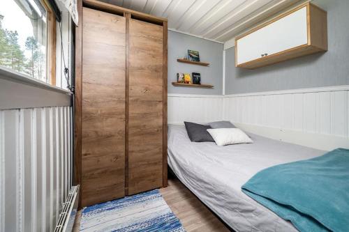 een slaapkamer met een bed en een grote houten deur bij Stinas Cabin in Kurravaara