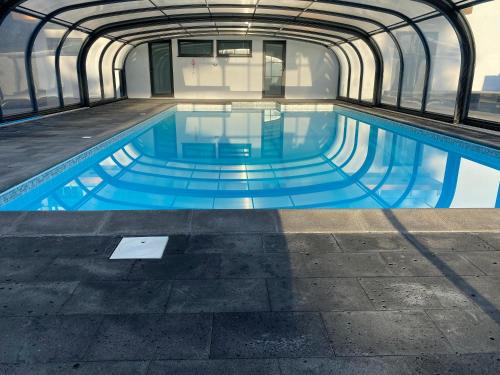 a swimming pool in a building with blue water at Villa MarAzul in Horta