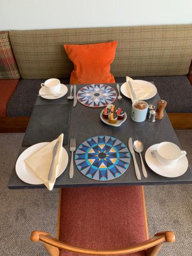 a table with plates and utensils on it at Leven House Bed and Breakfast in Crieff