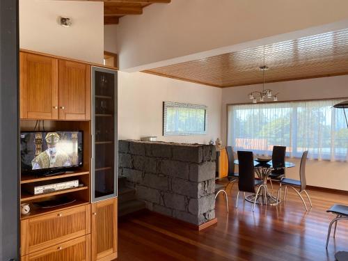 a living room with a stone fireplace and a dining room at Villa MarAzul in Horta